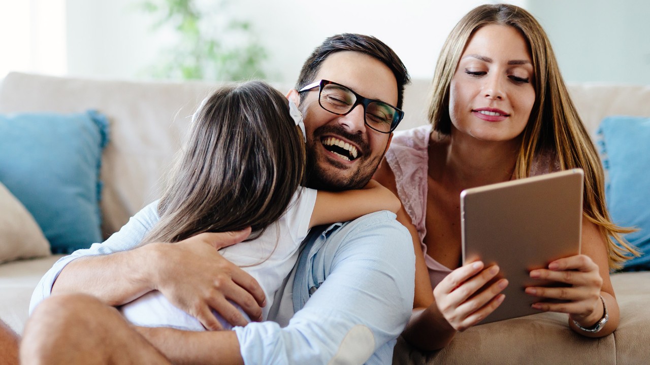 cheerful family using digital tablet